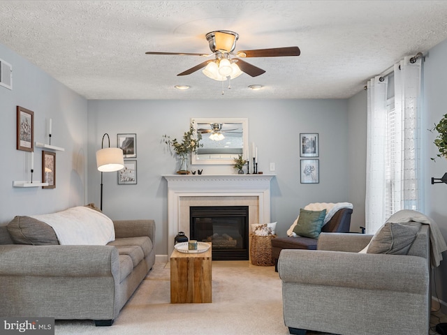 living room featuring ceiling fan, plenty of natural light, a textured ceiling, and light carpet