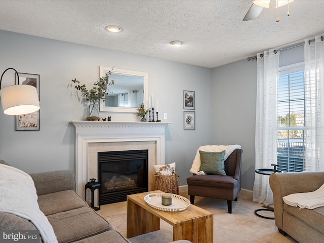 living room featuring light carpet, ceiling fan, and a textured ceiling