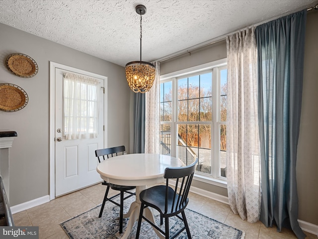 tiled dining area featuring a notable chandelier and a textured ceiling