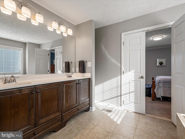 bathroom featuring a textured ceiling, tile patterned floors, and vanity