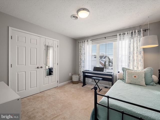 bedroom featuring carpet floors, a textured ceiling, and a closet