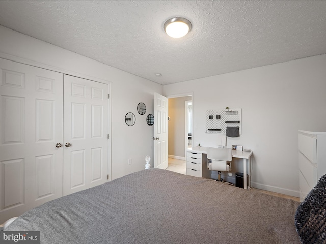 carpeted bedroom featuring a closet and a textured ceiling