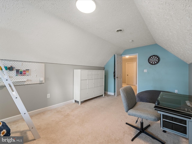 carpeted office featuring a textured ceiling and vaulted ceiling