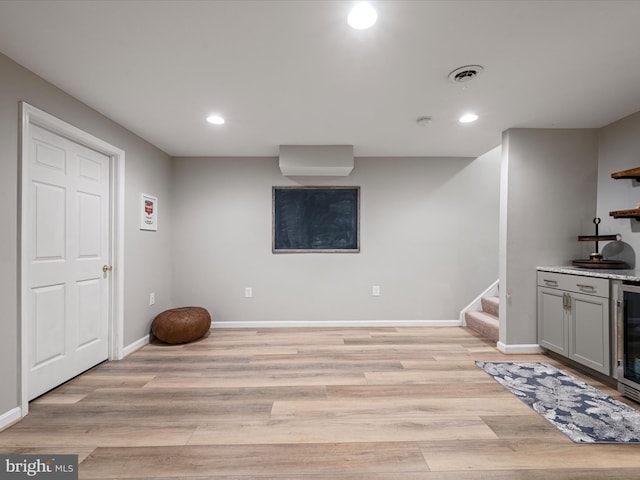 interior space featuring light hardwood / wood-style floors, gray cabinetry, and wine cooler