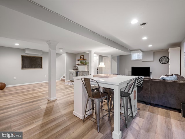 dining space featuring a wall mounted air conditioner and light hardwood / wood-style flooring