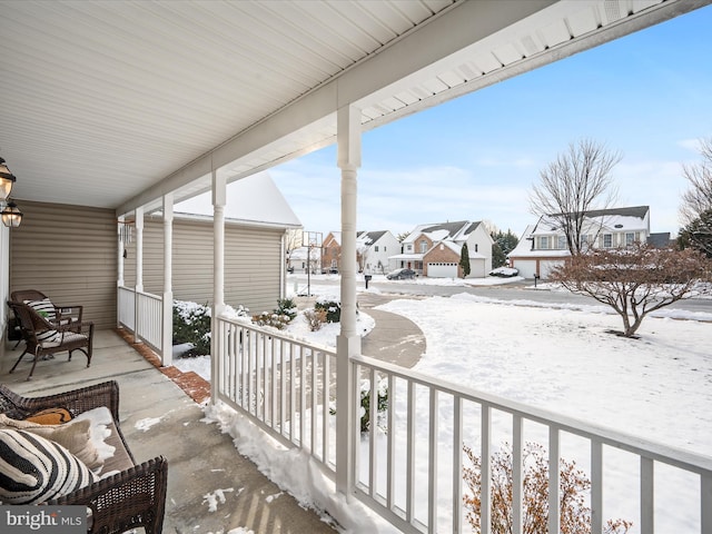 snow covered back of property with covered porch