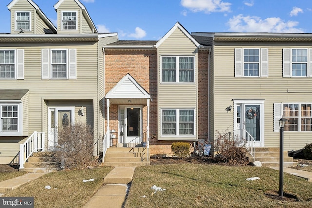 townhome / multi-family property featuring a front lawn