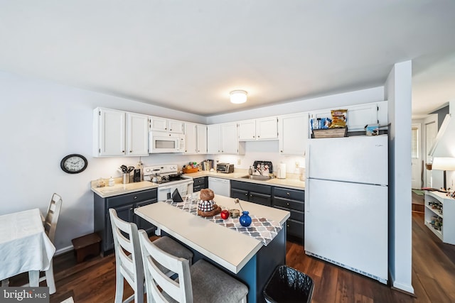 kitchen featuring white appliances, dark hardwood / wood-style flooring, sink, and white cabinets