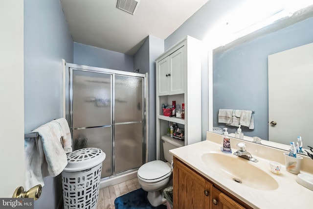 bathroom featuring vanity, toilet, and an enclosed shower