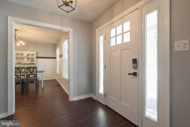 foyer entrance featuring an inviting chandelier and dark hardwood / wood-style flooring