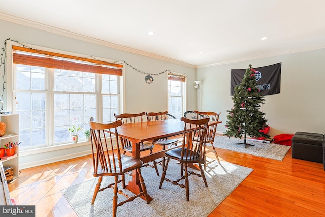 dining space with ornamental molding and light wood-type flooring