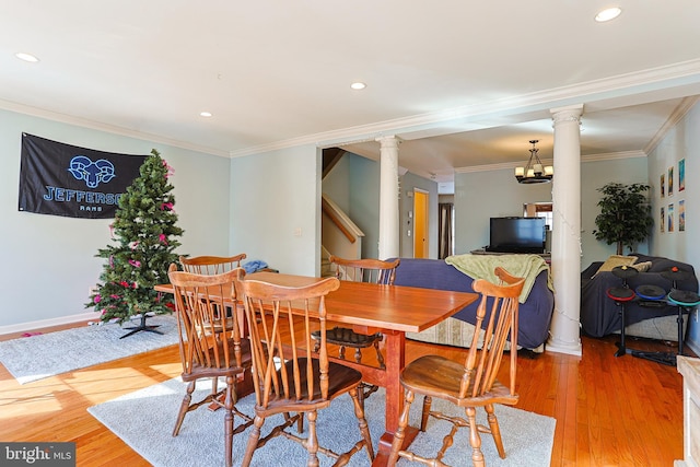 dining room featuring crown molding, light hardwood / wood-style floors, and ornate columns