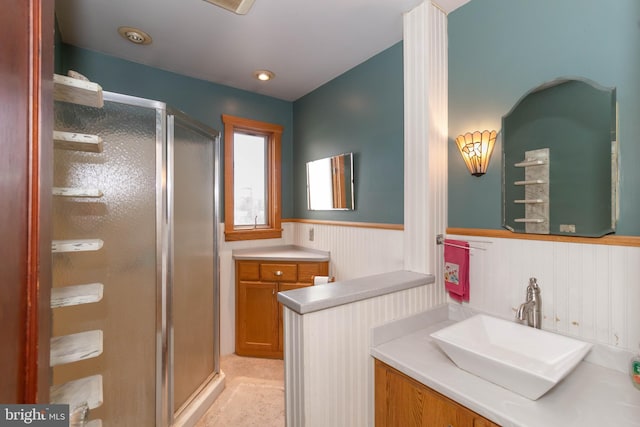 bathroom featuring vanity, wood walls, and a shower with shower door