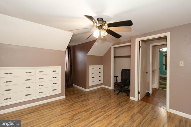 additional living space featuring wood-type flooring, lofted ceiling, and ceiling fan