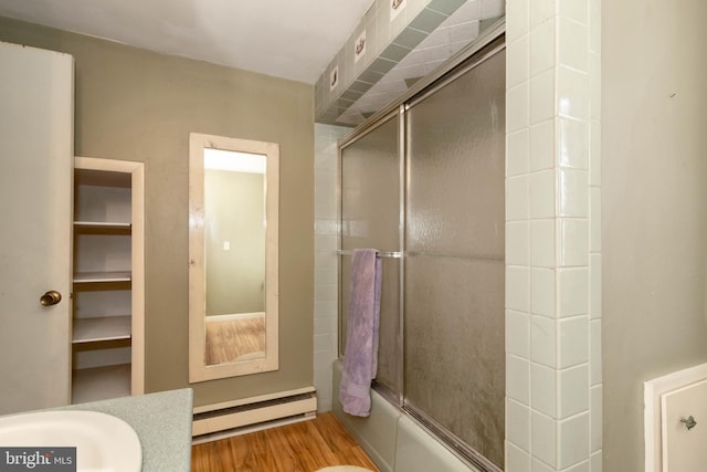 bathroom featuring baseboard heating, enclosed tub / shower combo, and wood-type flooring