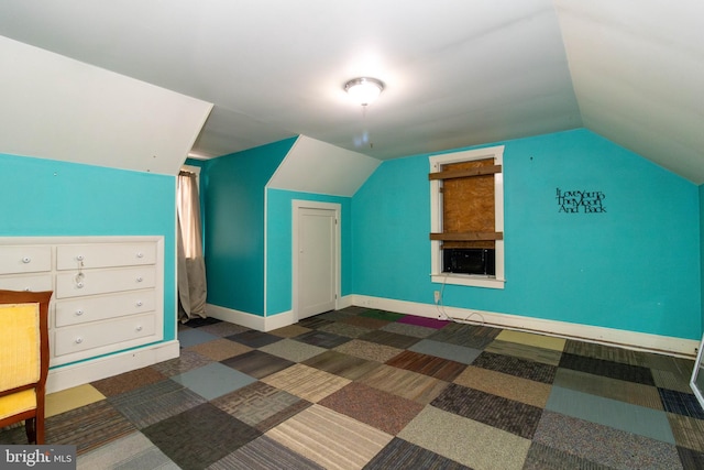 additional living space with vaulted ceiling and dark carpet