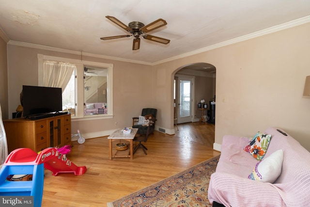 living room with hardwood / wood-style floors, crown molding, plenty of natural light, and ceiling fan