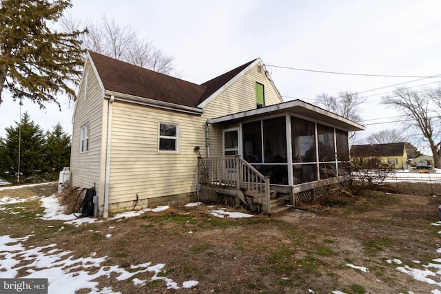 view of snowy exterior with a sunroom