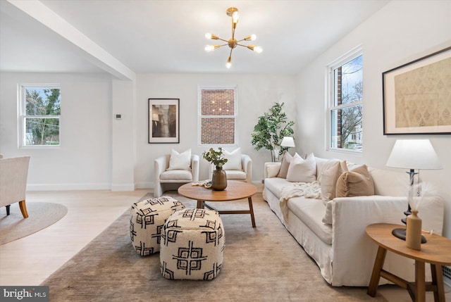 living room featuring a wealth of natural light, light hardwood / wood-style flooring, and an inviting chandelier