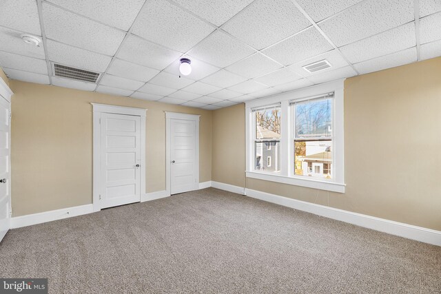 unfurnished bedroom with carpet flooring and a paneled ceiling