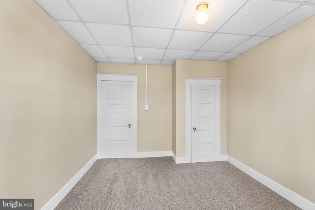 interior space with carpet floors and a drop ceiling