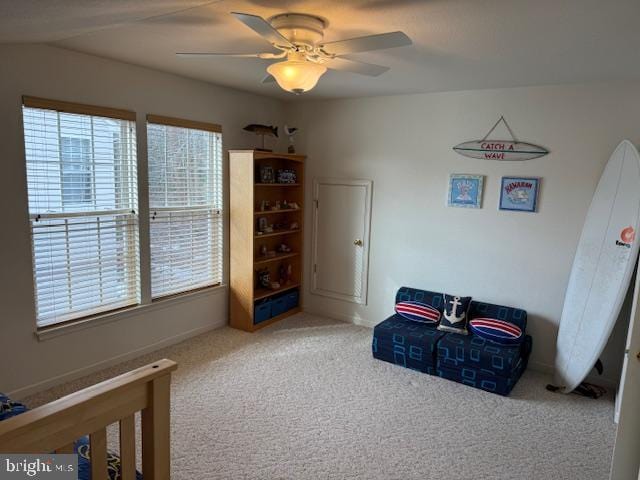 living area with ceiling fan, a wealth of natural light, and carpet flooring