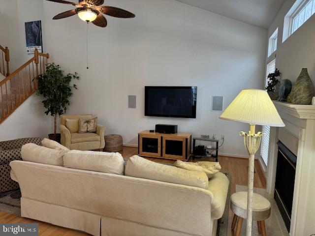 living room featuring wood-type flooring and ceiling fan