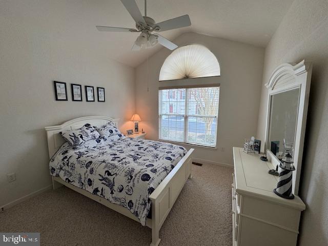 bedroom with light carpet, vaulted ceiling, and ceiling fan