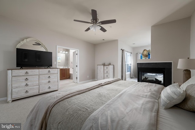 carpeted bedroom featuring ceiling fan, ensuite bath, and a multi sided fireplace