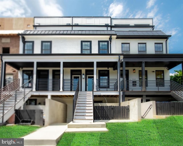 view of front of house with metal roof, stairway, and a standing seam roof