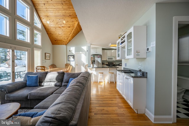 living room with lofted ceiling, light hardwood / wood-style flooring, and wooden ceiling