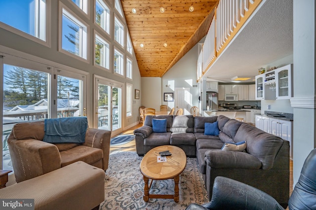 living room featuring high vaulted ceiling and wooden ceiling