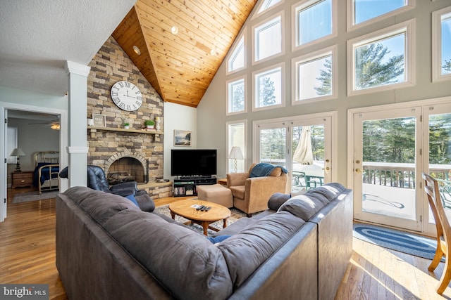 living room with wooden ceiling, wood-type flooring, a fireplace, and a high ceiling