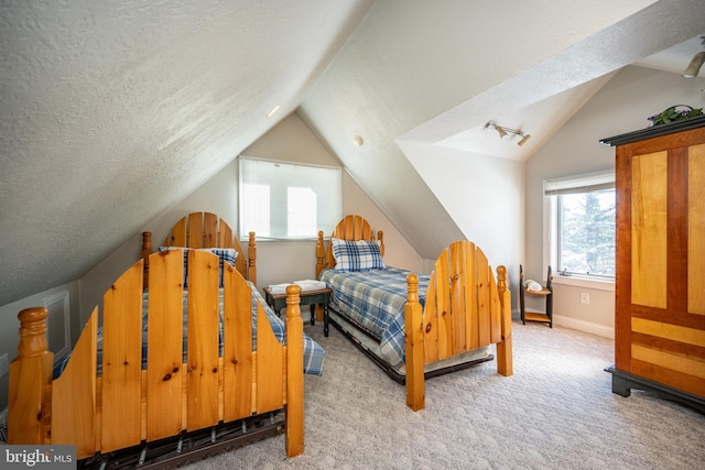 bedroom with multiple windows, carpet, and a textured ceiling