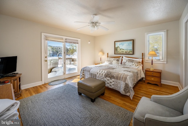 bedroom featuring ceiling fan, access to exterior, light hardwood / wood-style floors, and a textured ceiling