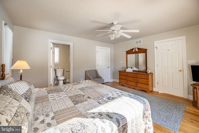 bedroom with connected bathroom, light hardwood / wood-style flooring, a textured ceiling, ceiling fan, and multiple windows