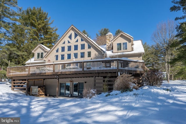 snow covered house with a wooden deck