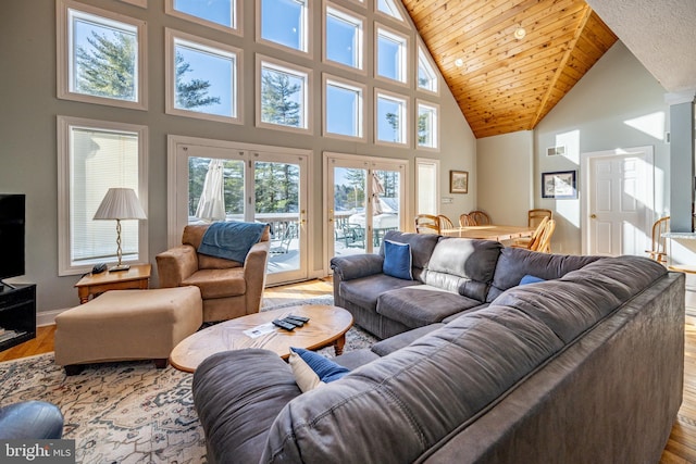 living room featuring wood ceiling, light hardwood / wood-style flooring, and a high ceiling