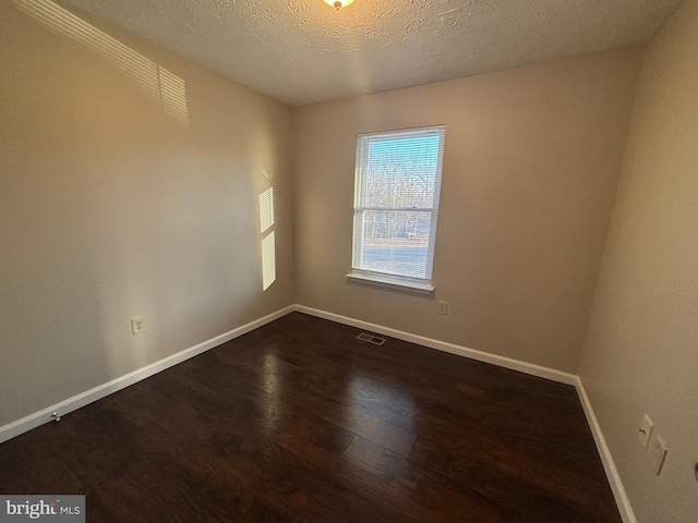 12725 Bar Oak Dr, Waldorf, MD 20601 - empty room featuring dark wood-type flooring and a textured ceiling