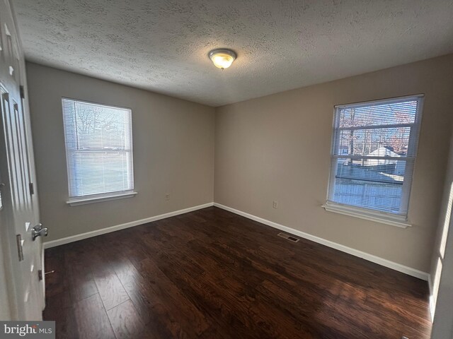 12725 Bar Oak Dr, Waldorf, MD 20601 - unfurnished room with dark hardwood / wood-style flooring, a textured ceiling, and a healthy amount of sunlight
