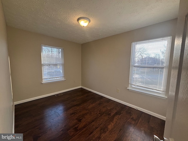 12725 Bar Oak Dr, Waldorf, MD 20601 - empty room with a healthy amount of sunlight, dark hardwood / wood-style floors, and a textured ceiling