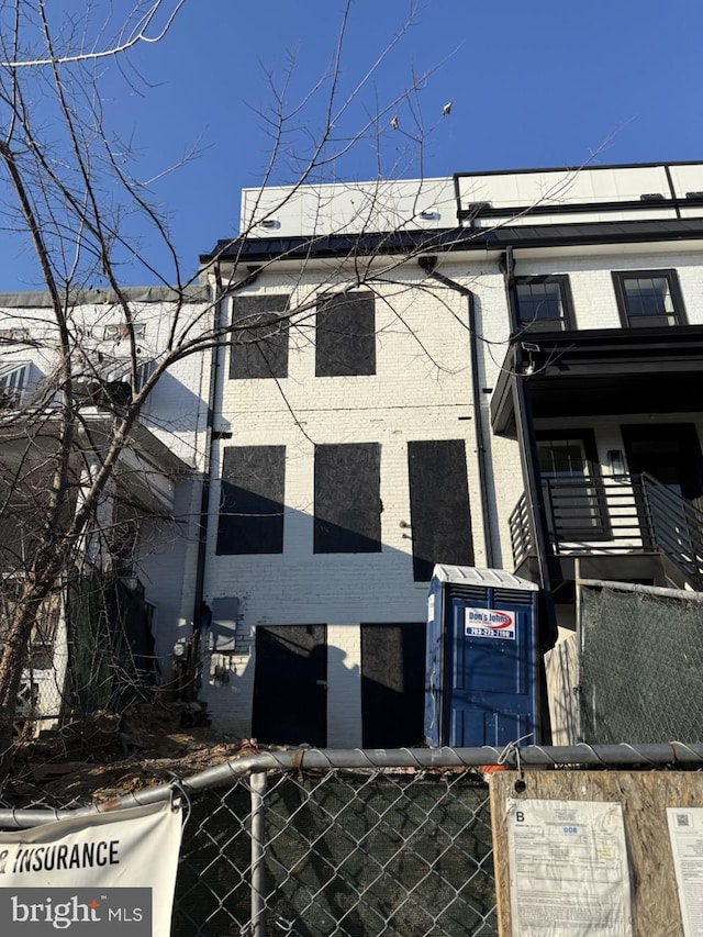 view of front facade with fence and brick siding