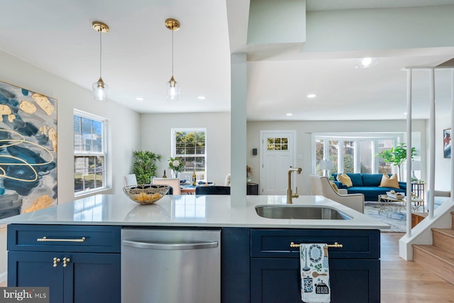 kitchen with sink, hanging light fixtures, stainless steel dishwasher, blue cabinetry, and light wood-type flooring