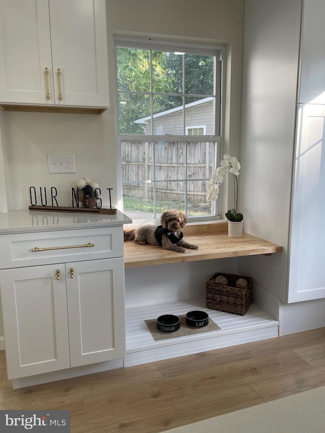 interior space with white cabinetry and light hardwood / wood-style flooring