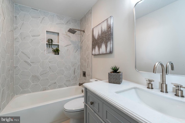 full bathroom featuring vanity, tiled shower / bath combo, and toilet