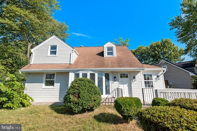 cape cod home featuring a front yard