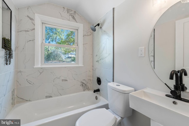 full bathroom with tiled shower / bath, vaulted ceiling, sink, and toilet