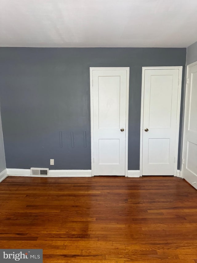 unfurnished bedroom with hardwood / wood-style floors