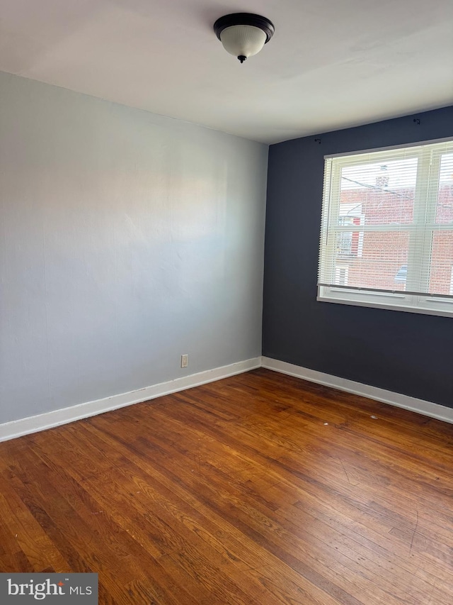 spare room featuring wood-type flooring