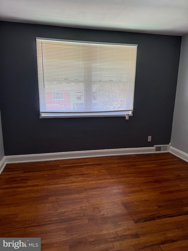 spare room featuring dark wood-type flooring